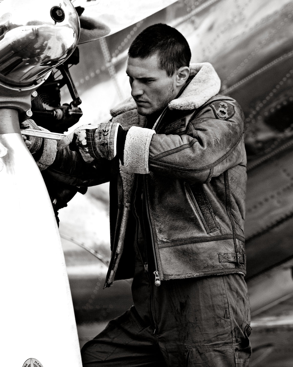 PME Legend archive photograph in black and white: a man in a flight jacket beside an aircraft propeller