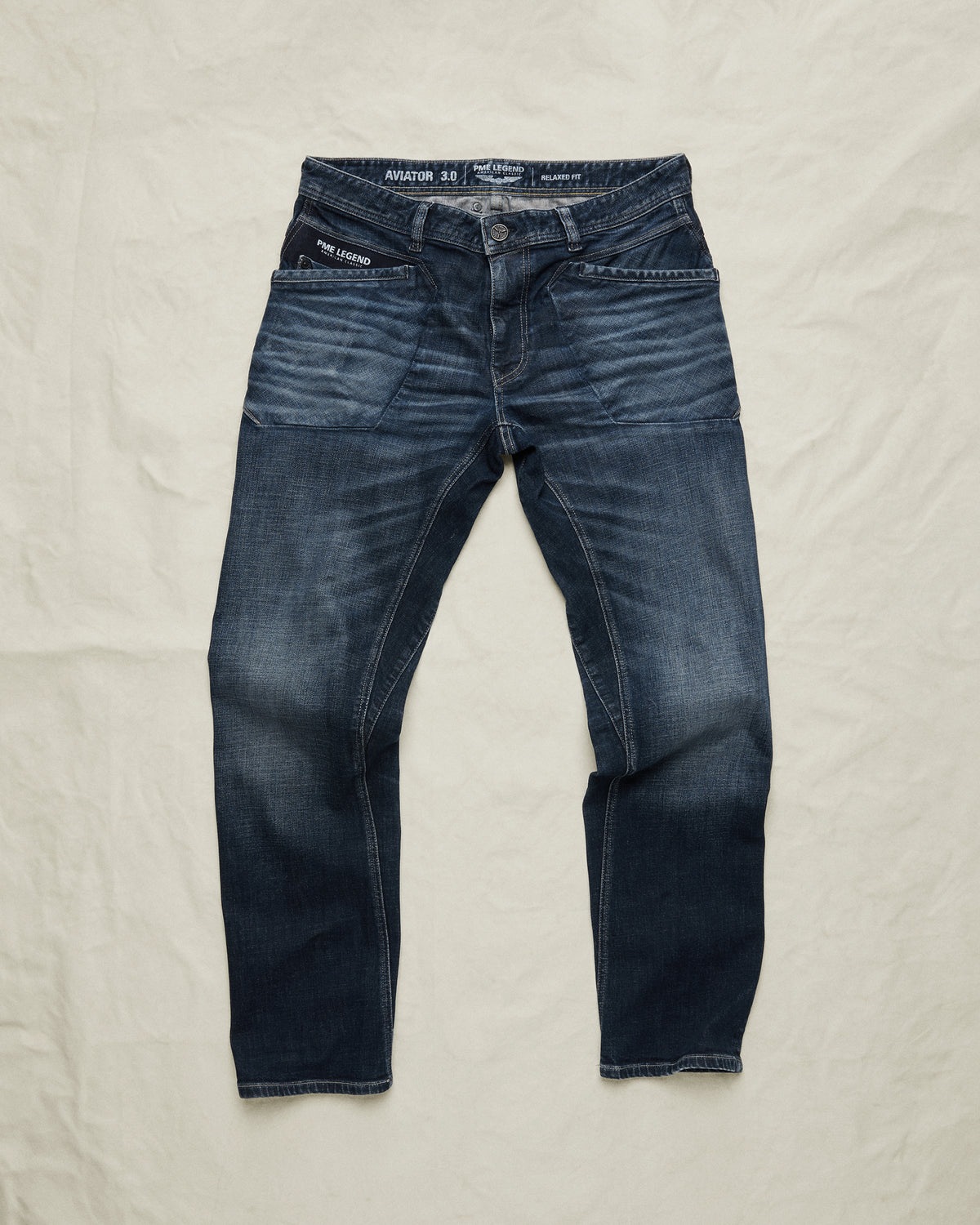 Indigo blue PME Legend jeans on a light fabric background