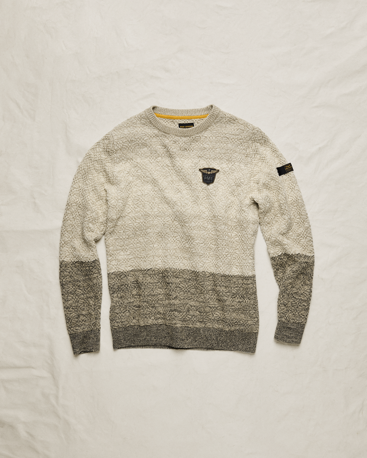 PME Legend knitwear in ecru and grey on a fabric background